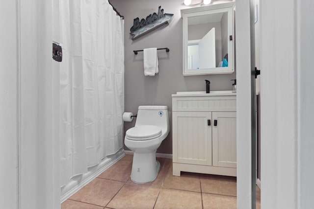 bathroom with tile patterned flooring, vanity, and toilet