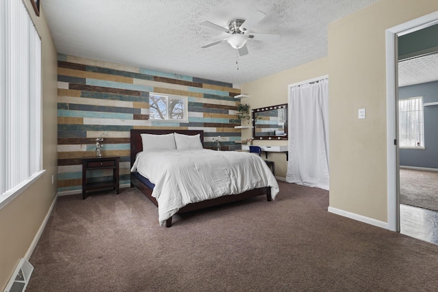 carpeted bedroom featuring a textured ceiling, ceiling fan, and wood walls