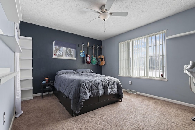 bedroom featuring ceiling fan, carpet flooring, and a textured ceiling