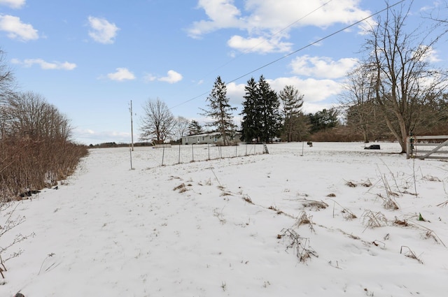 snowy yard featuring a rural view