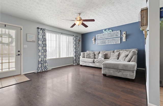 living room with ceiling fan, dark hardwood / wood-style flooring, and a textured ceiling