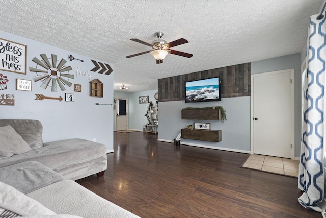 living room with ceiling fan, dark hardwood / wood-style flooring, and a textured ceiling