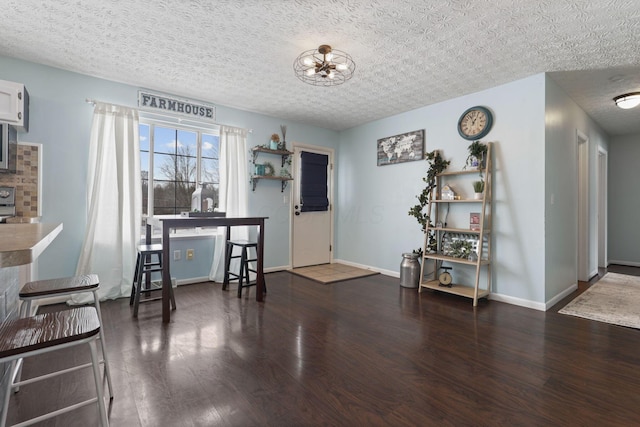 foyer entrance featuring dark wood-type flooring, a chandelier, and a textured ceiling