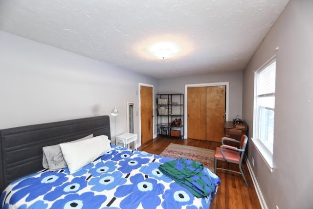 bedroom with dark hardwood / wood-style floors and a textured ceiling