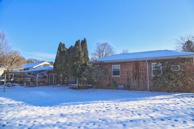 view of snow covered rear of property