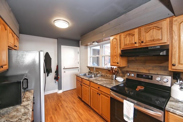 kitchen featuring sink, light wood-type flooring, stainless steel appliances, and light stone countertops