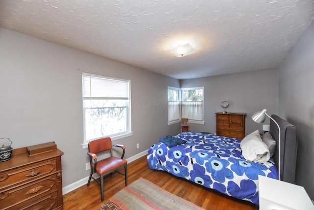 bedroom featuring wood-type flooring and a textured ceiling