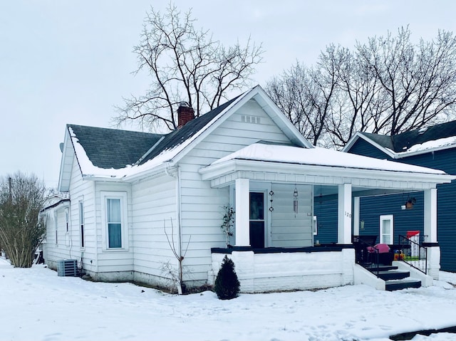 bungalow-style house with a porch and central AC unit