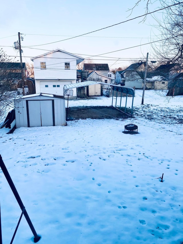 snowy yard with a storage shed