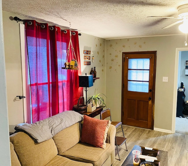 living room with light wood-type flooring, a textured ceiling, and ceiling fan