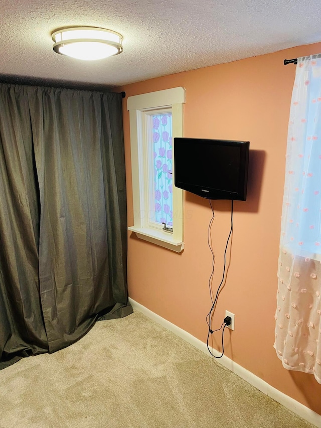 unfurnished bedroom with a textured ceiling and carpet flooring