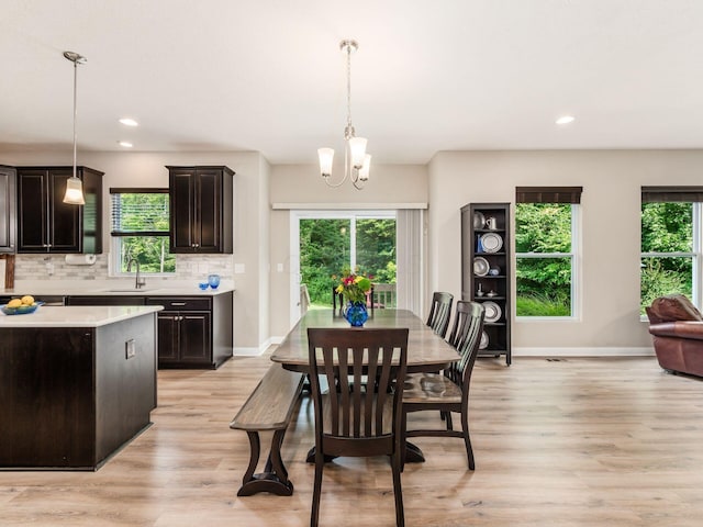 dining space featuring a wealth of natural light, light hardwood / wood-style flooring, and an inviting chandelier