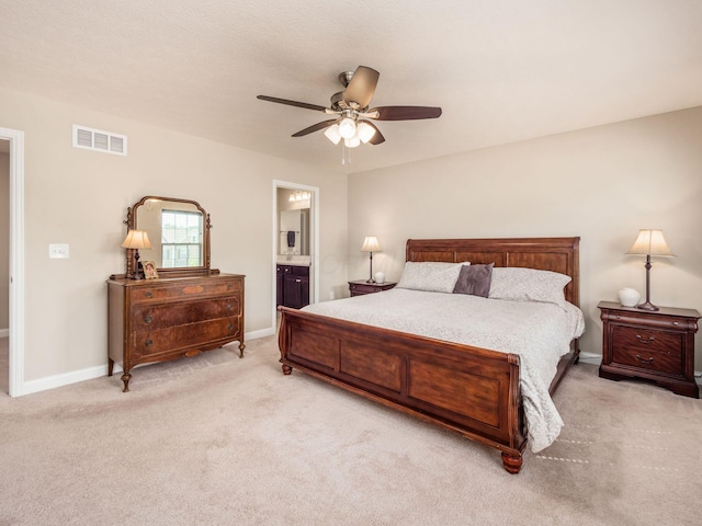 bedroom with ceiling fan, ensuite bathroom, and light carpet