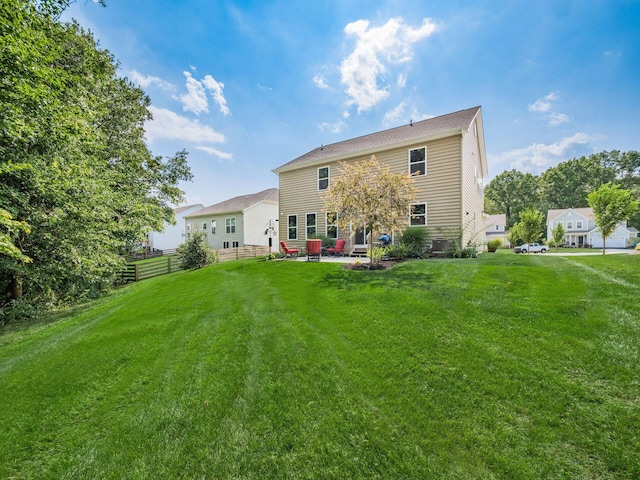 rear view of property with central AC unit, a yard, and a patio