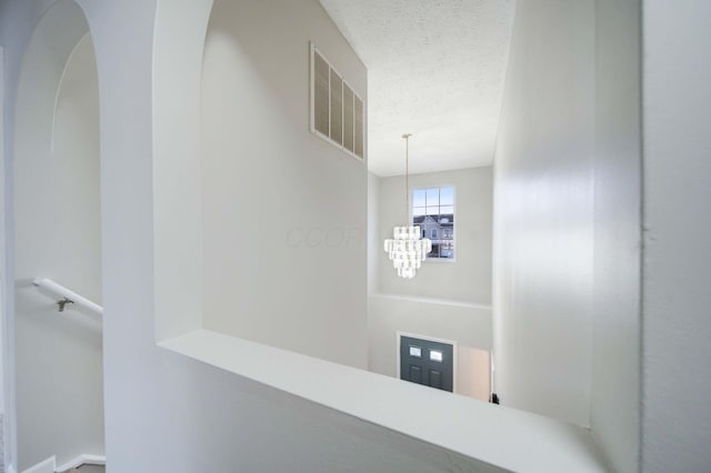 interior space with an inviting chandelier and a textured ceiling