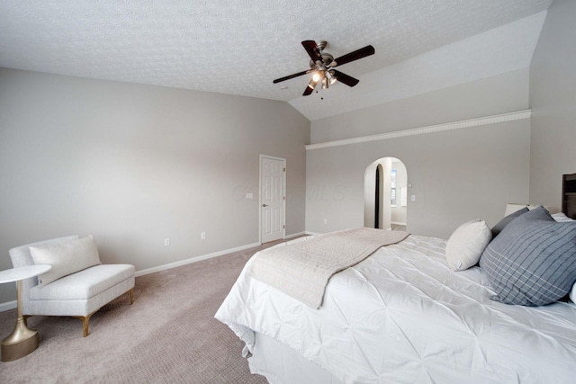 carpeted bedroom featuring ceiling fan, vaulted ceiling, and a textured ceiling