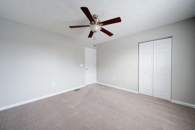 unfurnished bedroom with ceiling fan, a closet, carpet, and a textured ceiling