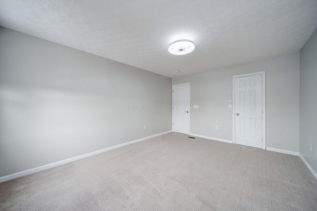 carpeted spare room with a textured ceiling