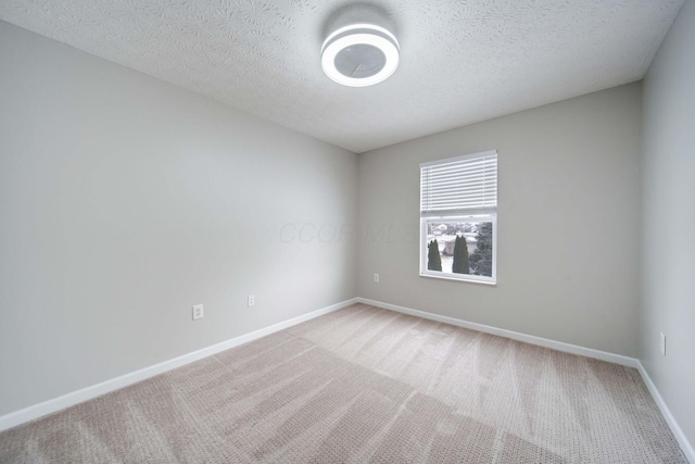 empty room featuring carpet and a textured ceiling