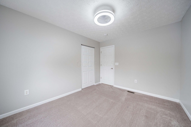 carpeted spare room featuring a textured ceiling