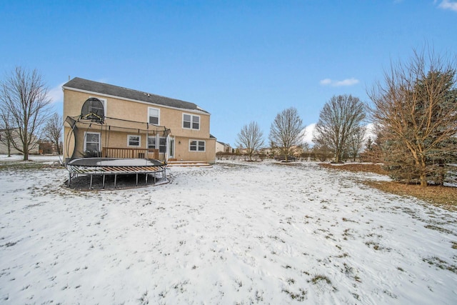 snow covered house with a trampoline