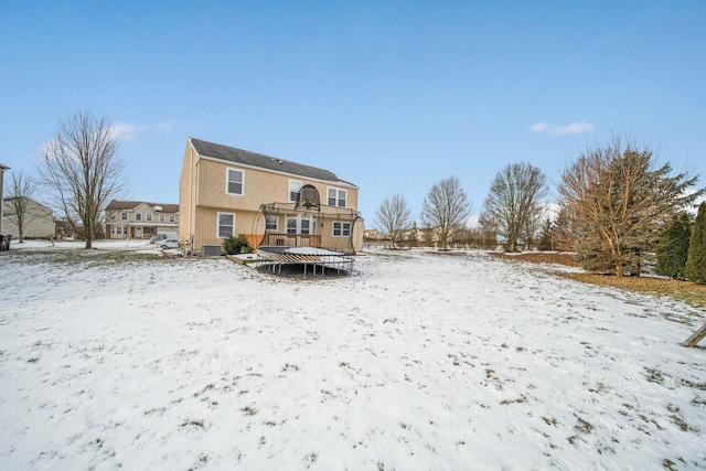 snow covered back of property with a trampoline and central air condition unit