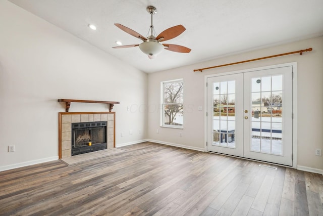 unfurnished living room with lofted ceiling, a wealth of natural light, french doors, and wood-type flooring