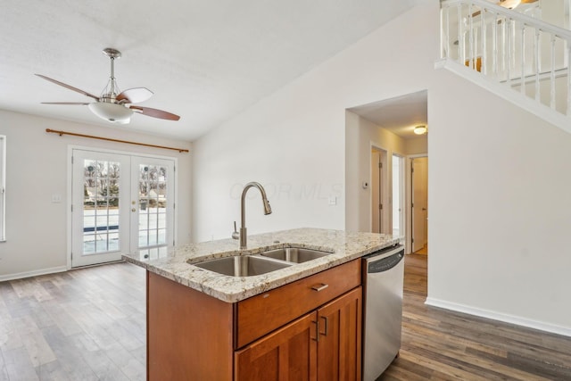 kitchen with sink, vaulted ceiling, a center island with sink, dishwasher, and hardwood / wood-style floors