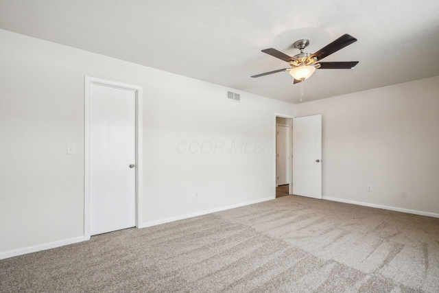 carpeted spare room with ceiling fan