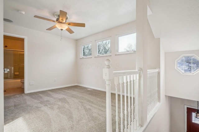 interior space featuring light colored carpet and ceiling fan