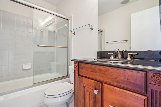 full bathroom featuring vanity, shower / bath combination with glass door, and toilet