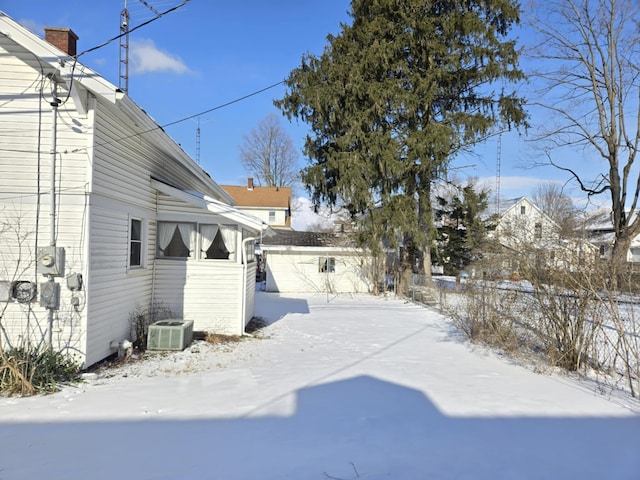 snowy yard featuring central air condition unit