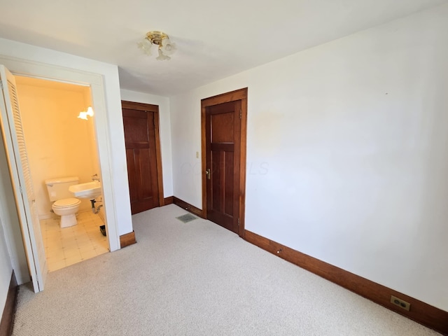 215 S Jefferson St, Galion, OH 44833 - unfurnished bedroom with visible vents, ensuite bathroom, a closet, carpet flooring, and baseboards