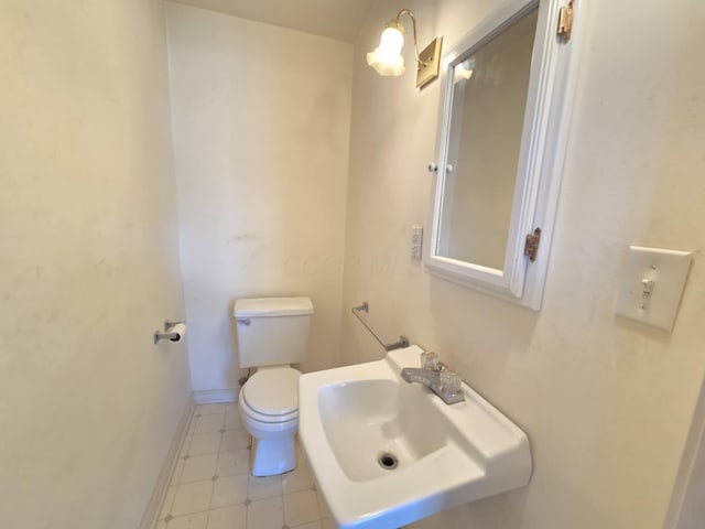 215 S Jefferson St, Galion, OH 44833 - bathroom featuring a sink, baseboards, and toilet