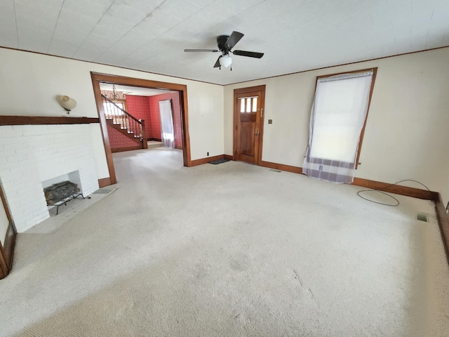 215 S Jefferson St, Galion, OH 44833 - unfurnished living room featuring a brick fireplace, baseboards, ceiling fan, stairs, and carpet flooring