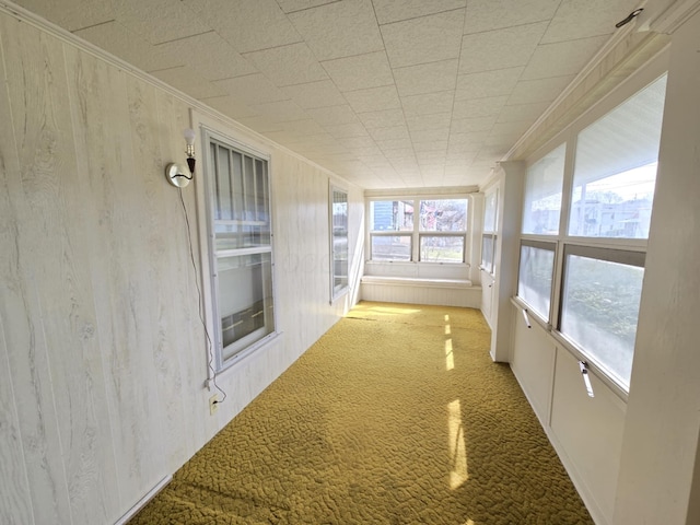 215 S Jefferson St, Galion, OH 44833 - unfurnished sunroom featuring crown molding, wooden walls, and carpet
