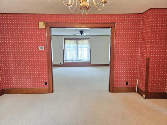 215 S Jefferson St, Galion, OH 44833 - carpeted empty room with baseboards, an inviting chandelier, and wallpapered walls