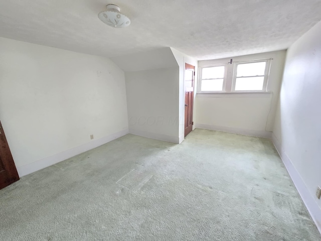 215 S Jefferson St, Galion, OH 44833 - additional living space with vaulted ceiling, carpet flooring, baseboards, and a textured ceiling
