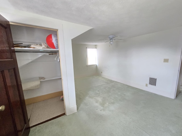 215 S Jefferson St, Galion, OH 44833 - interior space featuring visible vents, a ceiling fan, a textured ceiling, carpet floors, and baseboards