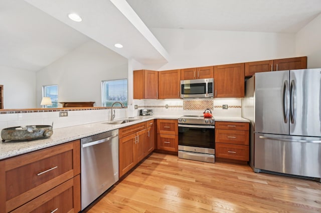 kitchen featuring sink, tasteful backsplash, high vaulted ceiling, light wood-type flooring, and stainless steel appliances