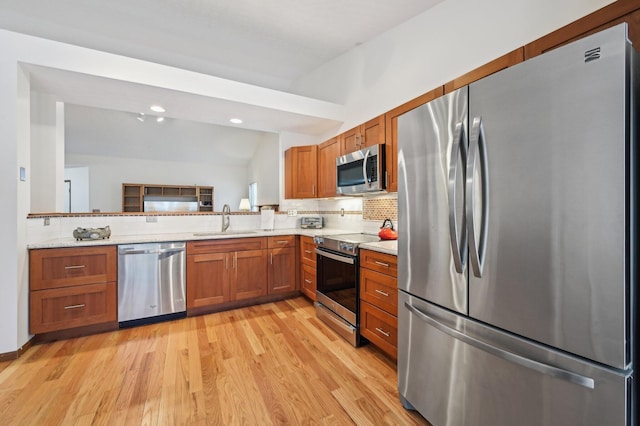 kitchen featuring appliances with stainless steel finishes, tasteful backsplash, lofted ceiling, sink, and kitchen peninsula