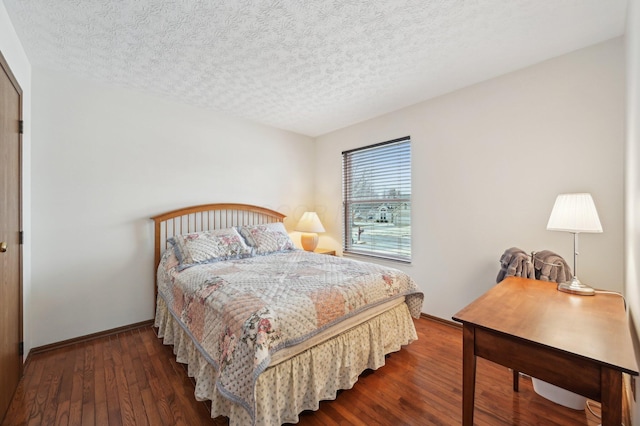 bedroom featuring dark wood-type flooring and a textured ceiling