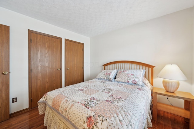 bedroom featuring dark hardwood / wood-style flooring and a textured ceiling