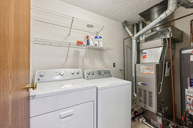 washroom featuring heating unit, independent washer and dryer, a textured ceiling, and gas water heater