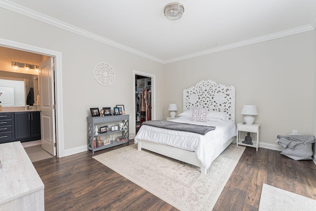 bedroom featuring ensuite bathroom, a spacious closet, crown molding, dark wood-type flooring, and a closet