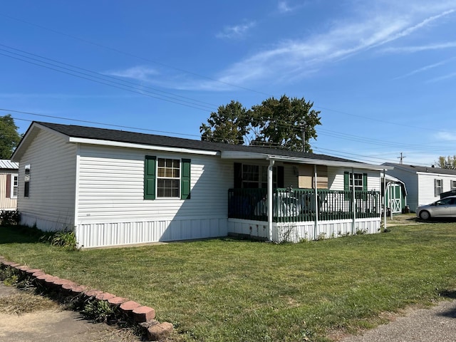 manufactured / mobile home with covered porch and a front yard