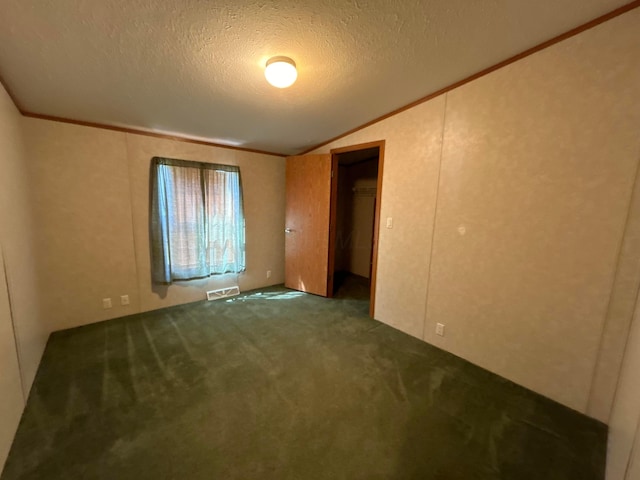 unfurnished bedroom featuring crown molding, vaulted ceiling, carpet floors, and a textured ceiling