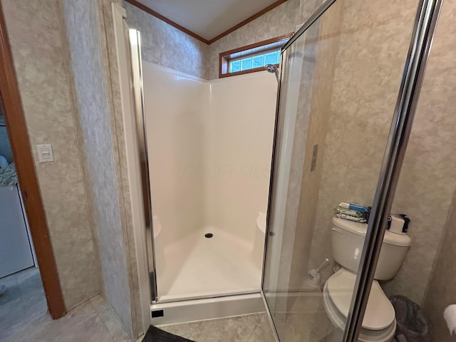 bathroom featuring crown molding, a shower with shower door, and toilet