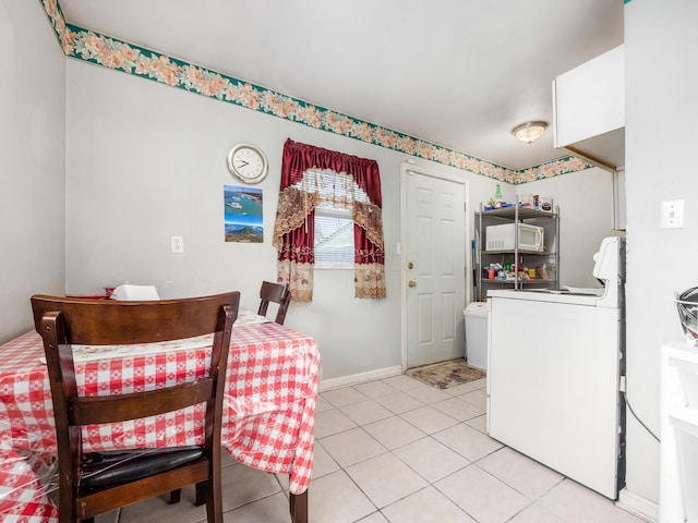 dining space featuring light tile patterned flooring and washer / clothes dryer