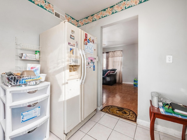 kitchen featuring light tile patterned floors and white refrigerator with ice dispenser